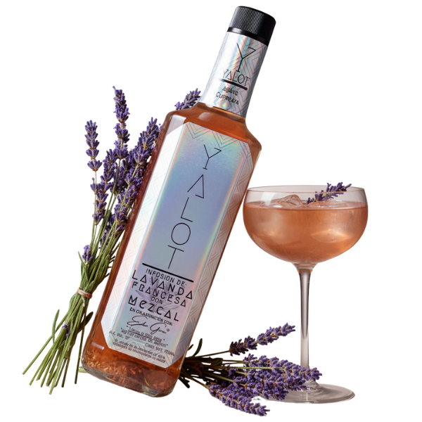 Botella infusión de lavanda con mezcal yalot con una copa servida y flores de lavanda de decoración