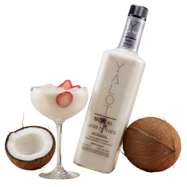 Botella de licor de coco con mezcal yalot con una copa servida con fresas y hielos y un coco partido de decoración