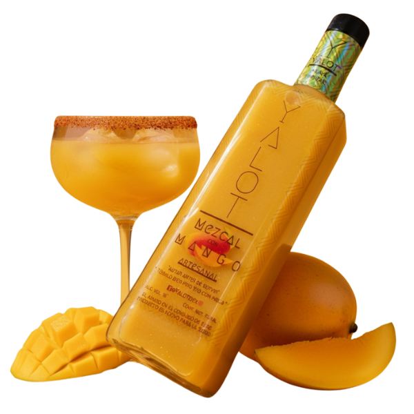 Botella de mezcal con mango yalot con una copa servida con hielos y escarchada y un mango partido de decoración